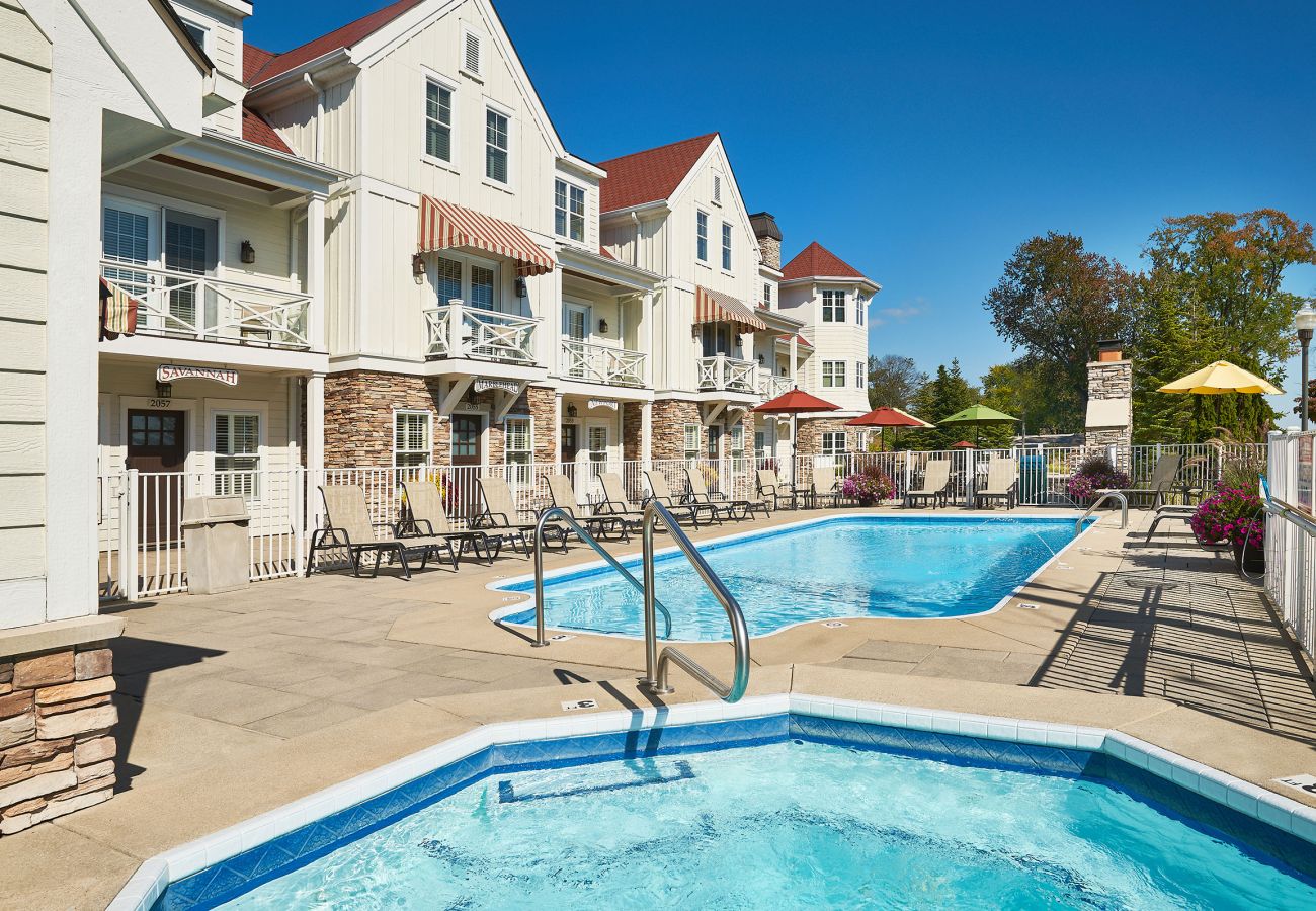 Swimming pool with spa and comfortable seating with umbrellas 